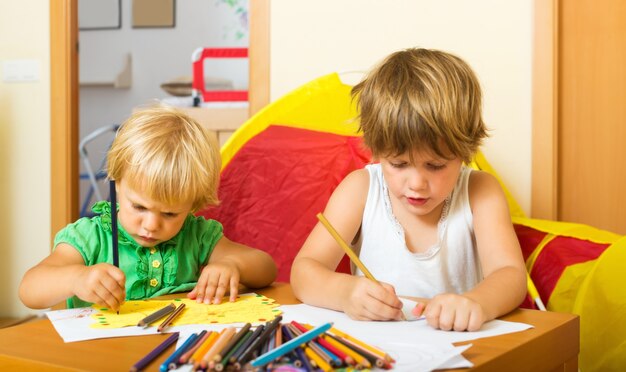 Irmãos brincando com lápis