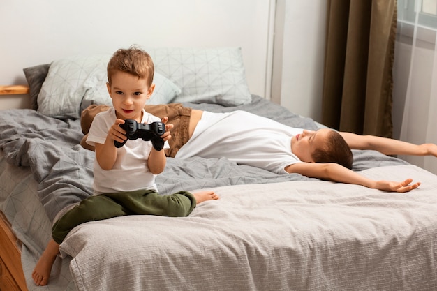 Foto grátis irmãos de tiro completo jogando videogame