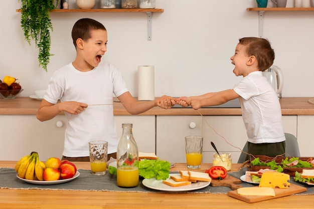 Foto grátis irmãos de tiro médio com comida em casa