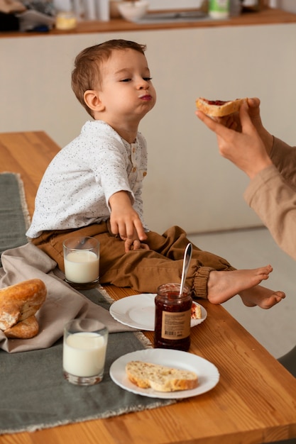 Foto grátis irmãos de vista lateral com comida em casa