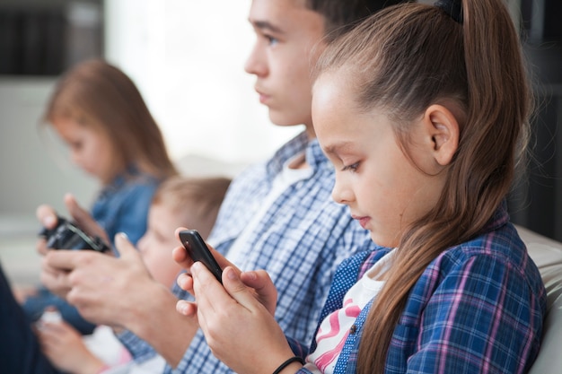 Irmãos de vista lateral com smartphone e controlador