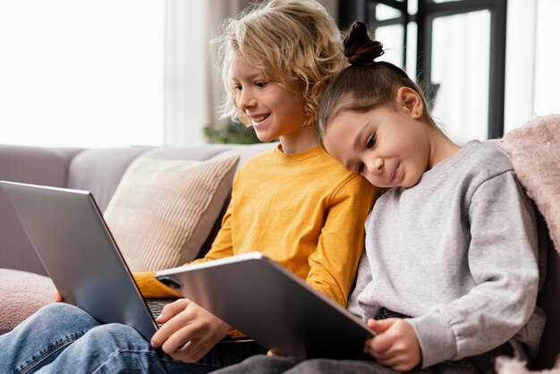 Irmãos em casa com dispositivos