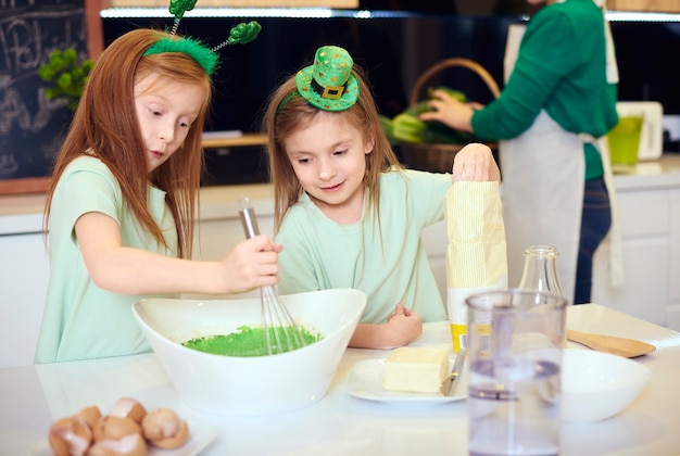 Irmãos misturando cobertura de fondant verde