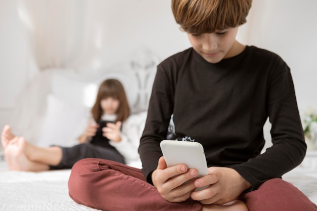 Irmãos no quarto com telefone