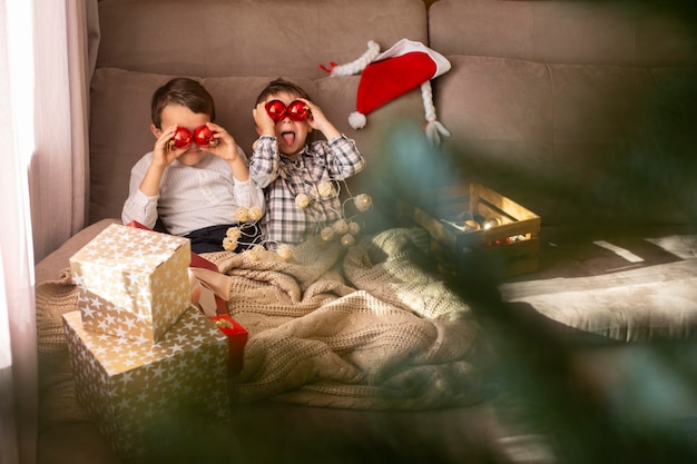 Irmãos pequenos adoráveis passando um tempo juntos no natal