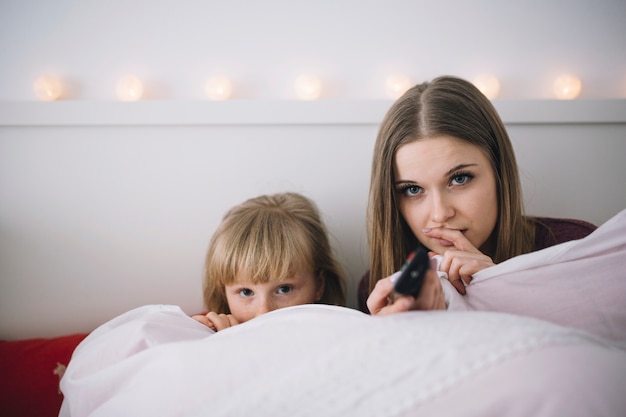 Irmãs assistindo tv na cama