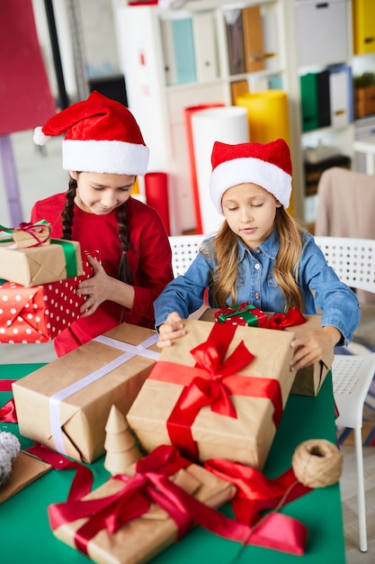 Foto grátis irmãs felizes garotas com presentes de natal