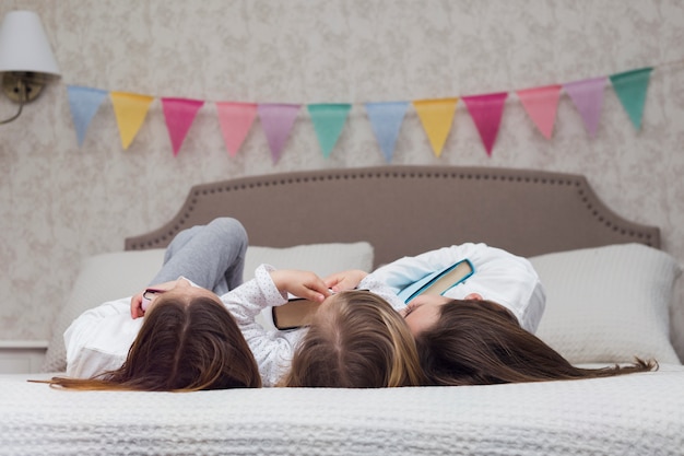 Foto grátis irmãs lendo livro juntos