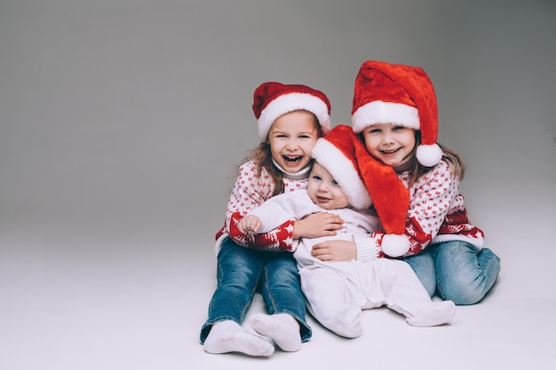 Irmãs rindo com irmãozinho no Natal