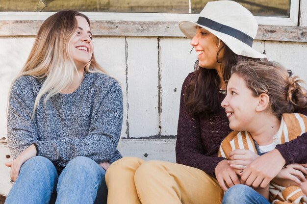 Irmãs sorridentes felizes sentado ao ar livre