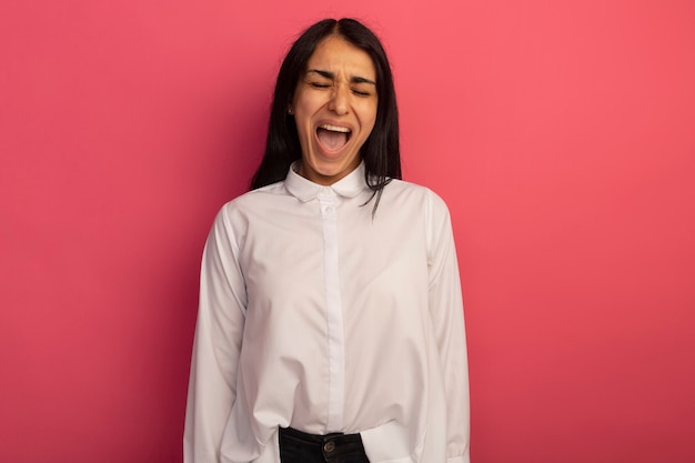 Irritada com os olhos fechados, jovem mulher bonita vestindo uma camiseta branca