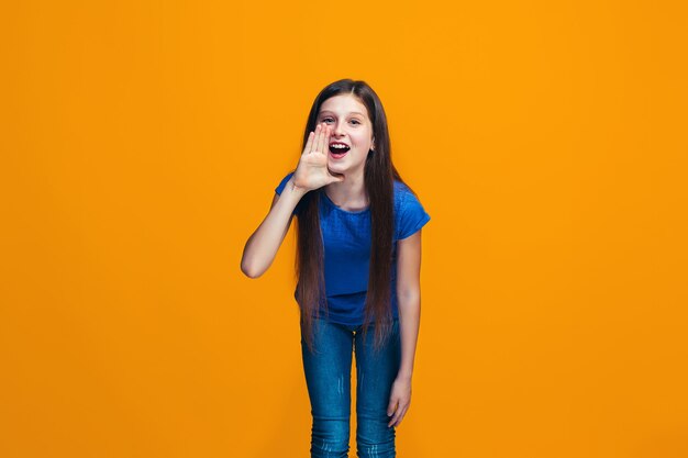 Isolado em amarelo jovem casual adolescente gritando no estúdio