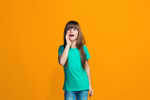 Foto grátis isolado em amarelo jovem casual adolescente gritando no estúdio