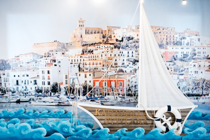 Foto grátis jacht de madeira decorativo fica diante de uma foto de porto marítimo na parede
