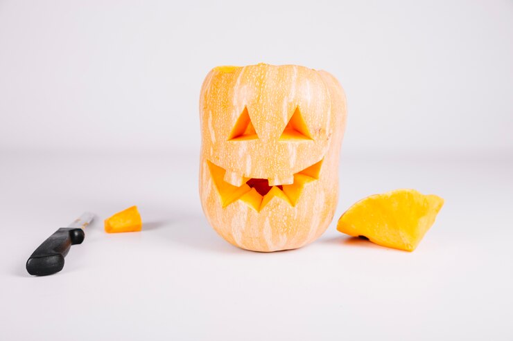 Foto grátis jack-o-lantern esculpido com abóbora com faca