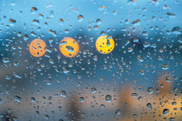 Foto grátis janela de vidro coberta de gotas de chuva com luzes no fundo desfocado
