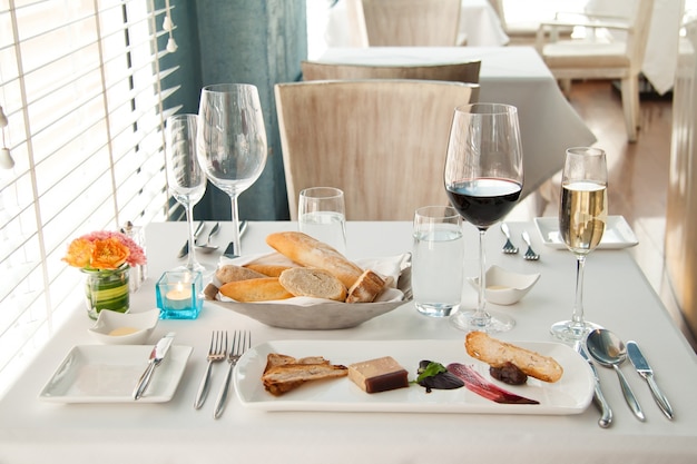Foto grátis jantar ajustado na mesa branca, conjunto luxuoso completo de jantar francês