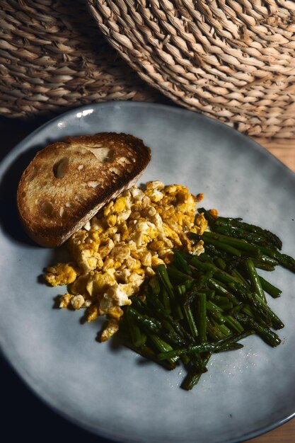 Jantar rústico com omelete de aspargos fritos e pão torrado ao lado de decorações tecidas