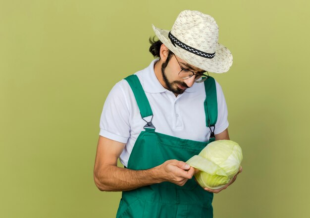 Jardineiro sem noção com óculos óticos e chapéu de jardinagem segurando repolho