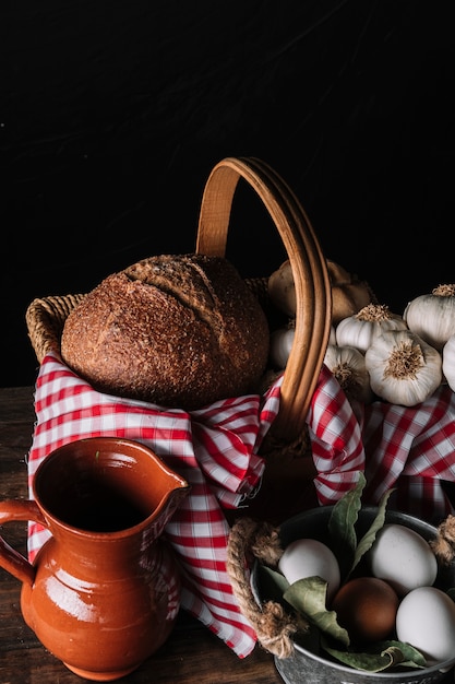 Foto grátis jarro e ovos perto de cesta com comida