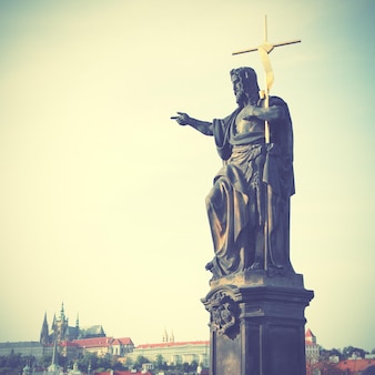 Jesus com cruz na ponte de charle em praga, república tcheca. imagem filtrada de estilo retro