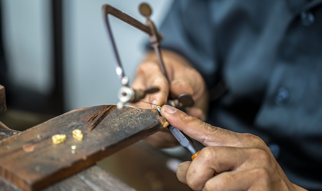 Joalheiro tailandês, lida com joias e pedras preciosas na oficina, processo de fabricação de joias, close-up