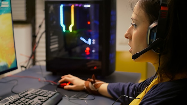 Foto grátis jogador competitivo usando equipamento rgb para campeonato ao vivo, jogando em um potente computador profissional. transmissão cibernética online durante torneios de jogos usando tecnologia de rede sem fio