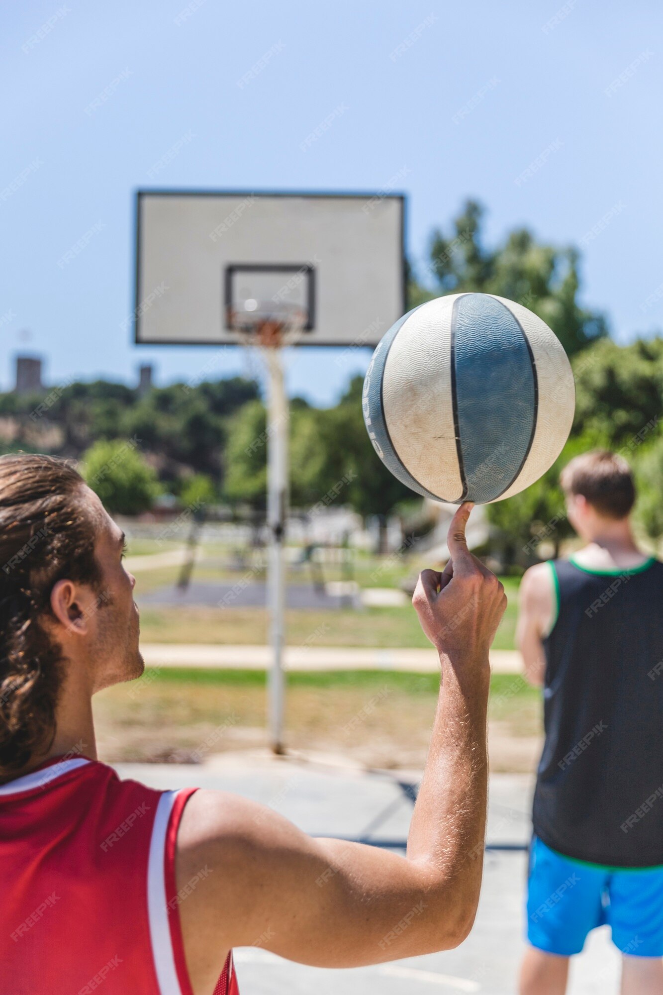 Girando a bola de basquete laranja em um dedo.