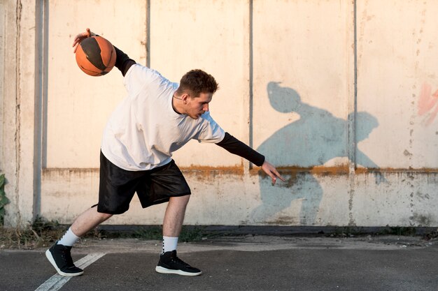 Jogador de basquete lateral na quadra urbana
