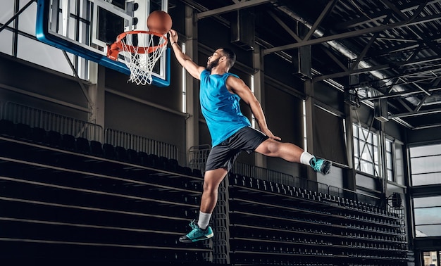 Jogador de basquete preto profissional preto em ação em uma quadra de basquete.