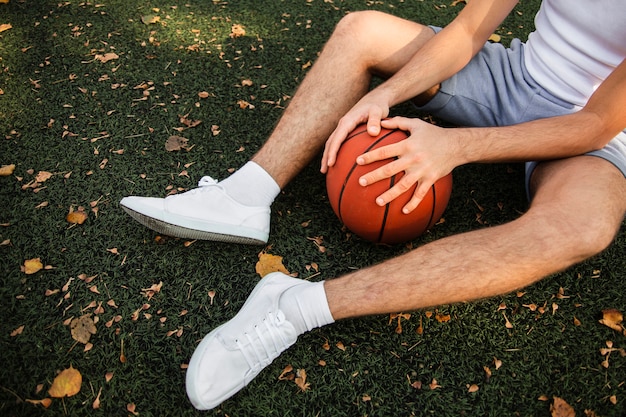 Jogador de basquete, sentado na grama