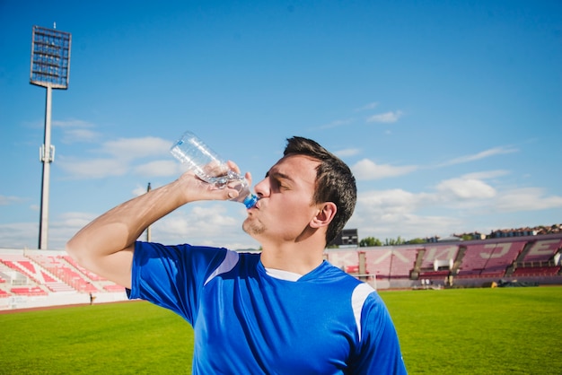 Jogador de futebol bebendo água