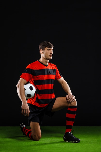 Jogador de futebol com bola em pé no joelho, jogar futebol