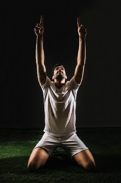 Foto grátis jogador de futebol comemorando a vitória