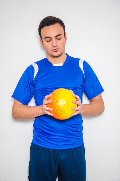 Jogador de futebol concentrado segurando bola