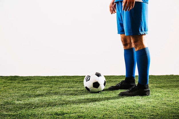 Jogador de futebol de colheita perto de bola