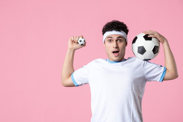 Jogador de futebol de frente com roupas esportivas e bola