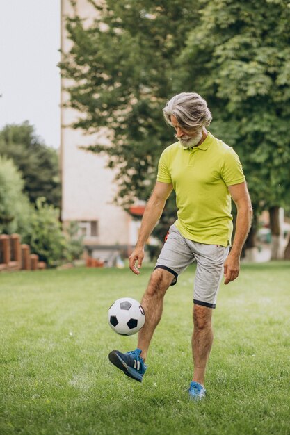 Jogador de futebol de meia-idade com bola de futebol