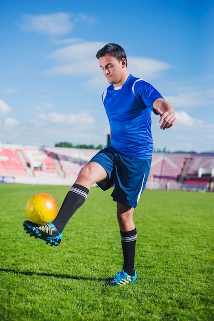 Foto grátis jogador de futebol equilibrando a bola a pé