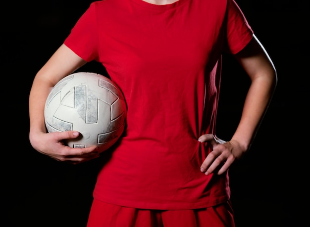 Jogador de futebol feminino com bola de perto