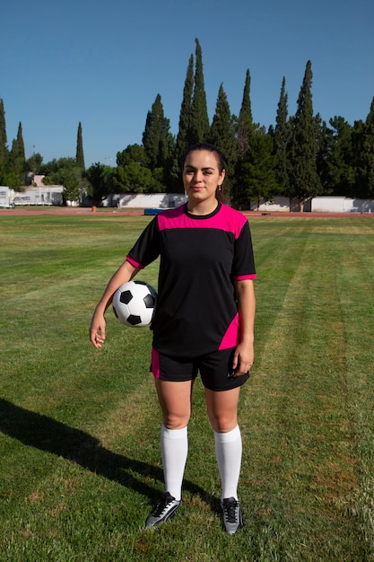 Foto grátis jogador de futebol feminino de tiro completo no campo