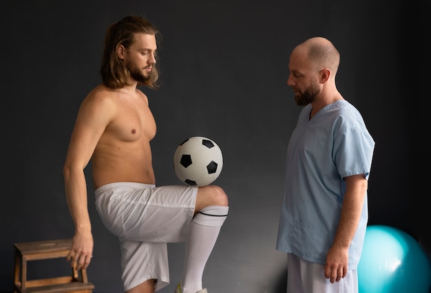 Foto grátis jogador de futebol na vista lateral de fisioterapia