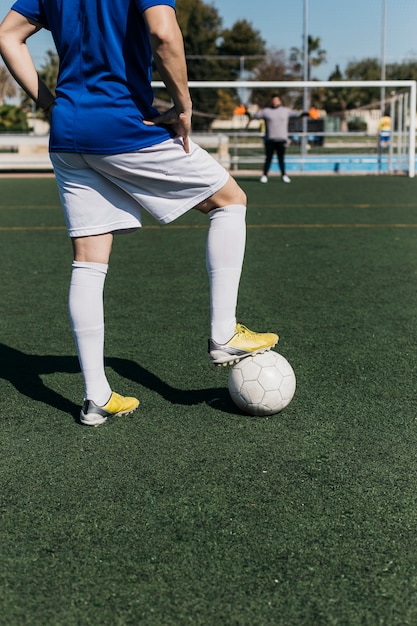 Jogador de futebol, olhando em direção a meta