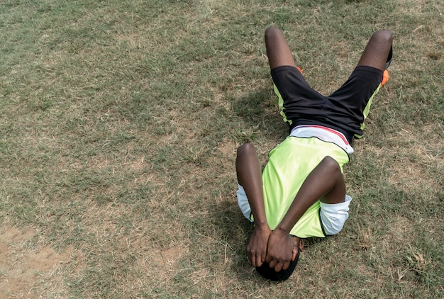 Jogador de futebol sentado no campo