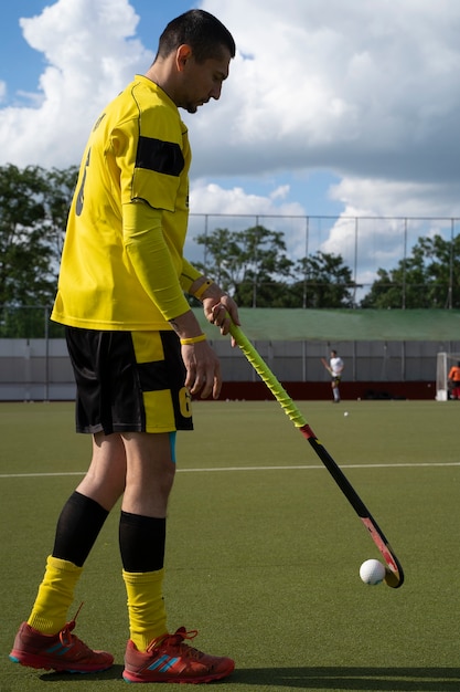 Foto grátis jogador de hóquei em campo em equipamentos na grama