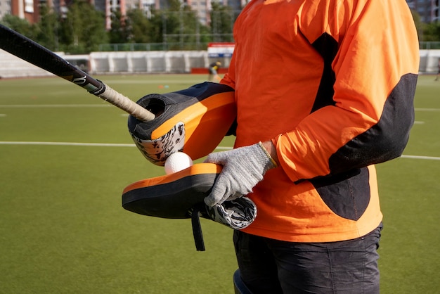 Foto grátis jogador de hóquei em campo em equipamentos na grama