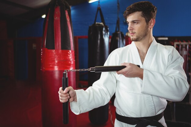 Jogador de karatê praticando com nunchaku