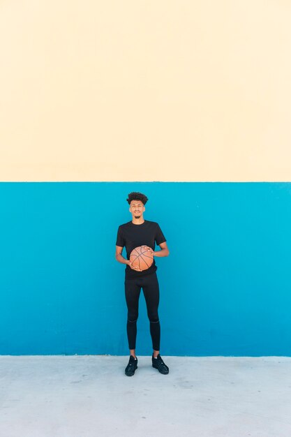 Jogador étnico com basquete na rua