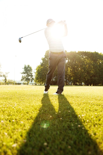 Foto grátis jogador profissional de golfe masculino batendo com um motorista de um tee