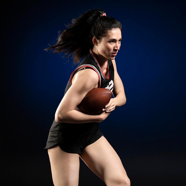 Jogadora de rugby em roupas esportivas posando